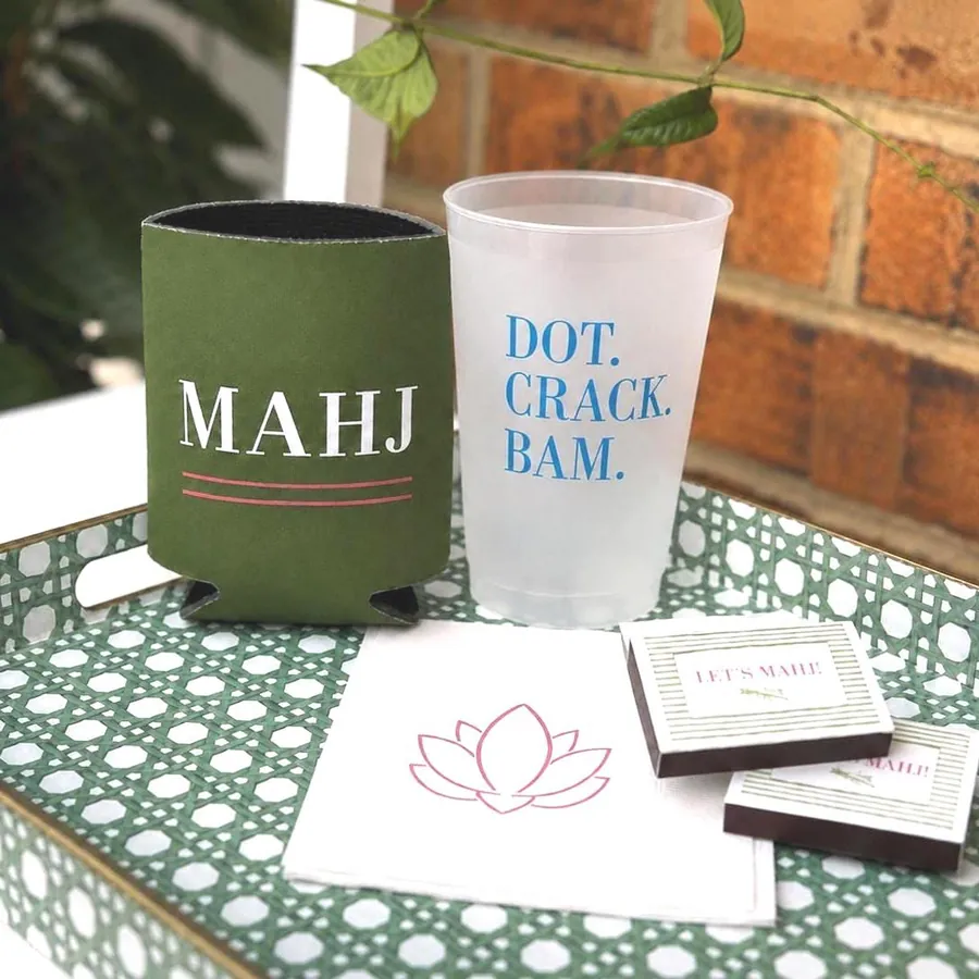 A MAHJ can cooler, frosted cup, lotus napkin and matchbox favors