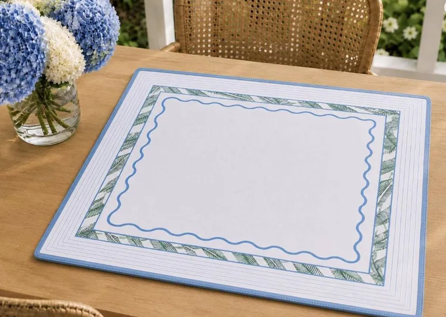 A Mary Grace Mahjong mat on a wood table with hydrangeas