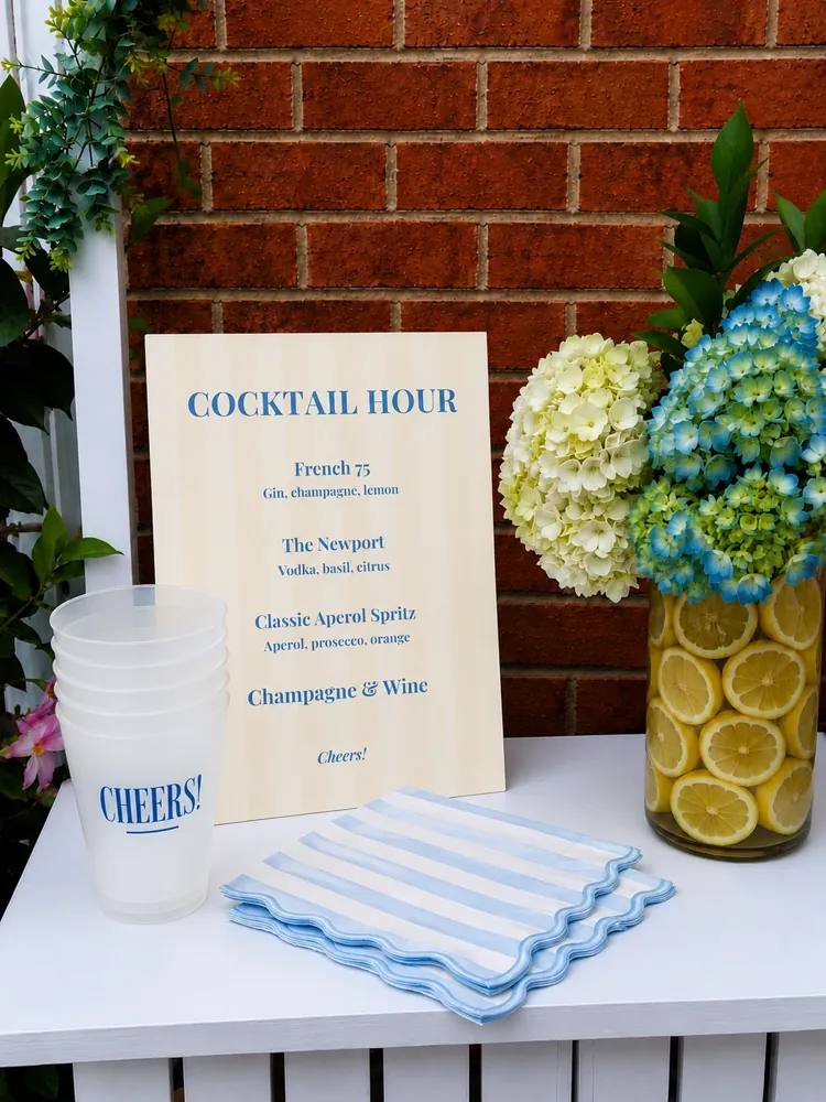 A striped cocktail hour sign with hydrangeas and lemons