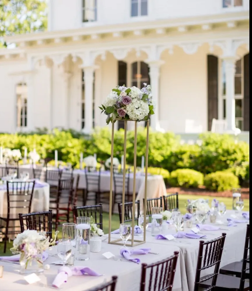 A long garden reception table in front of a white house