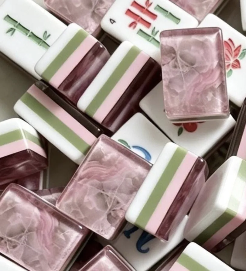 Pink and green Mahjong tiles on a rattan rack